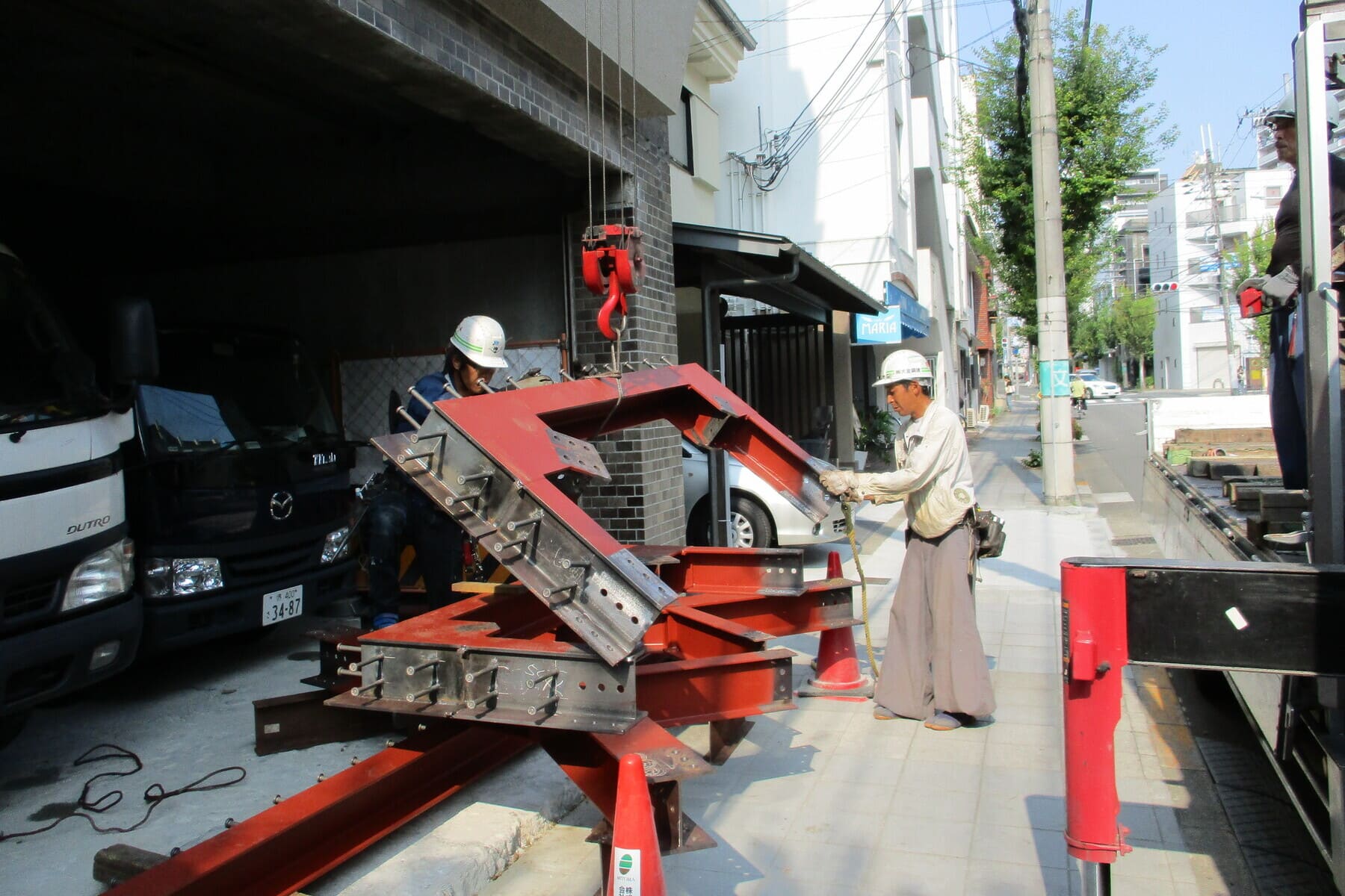 大阪市玉造のビルリノベ。耐震改修工事の最大の山場、鉄骨ブレースの取り付け工事を行いました。バルコニーの腰壁と、空中を縦横無尽に走っている電線が邪魔で工場一体製作を断念。パーツごとに分けて障害物を避け、室内へ搬入してから組み立てます。