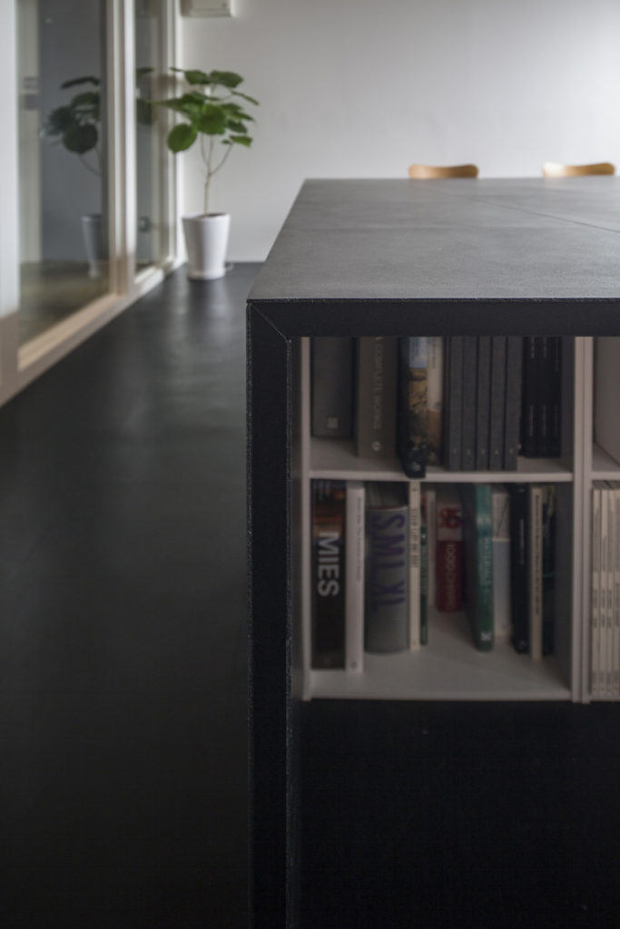 ディテール。既成品の本棚を4列格納している。メーカーのカタログや事務用品を収めて、事務所然とした雰囲気にならないように。