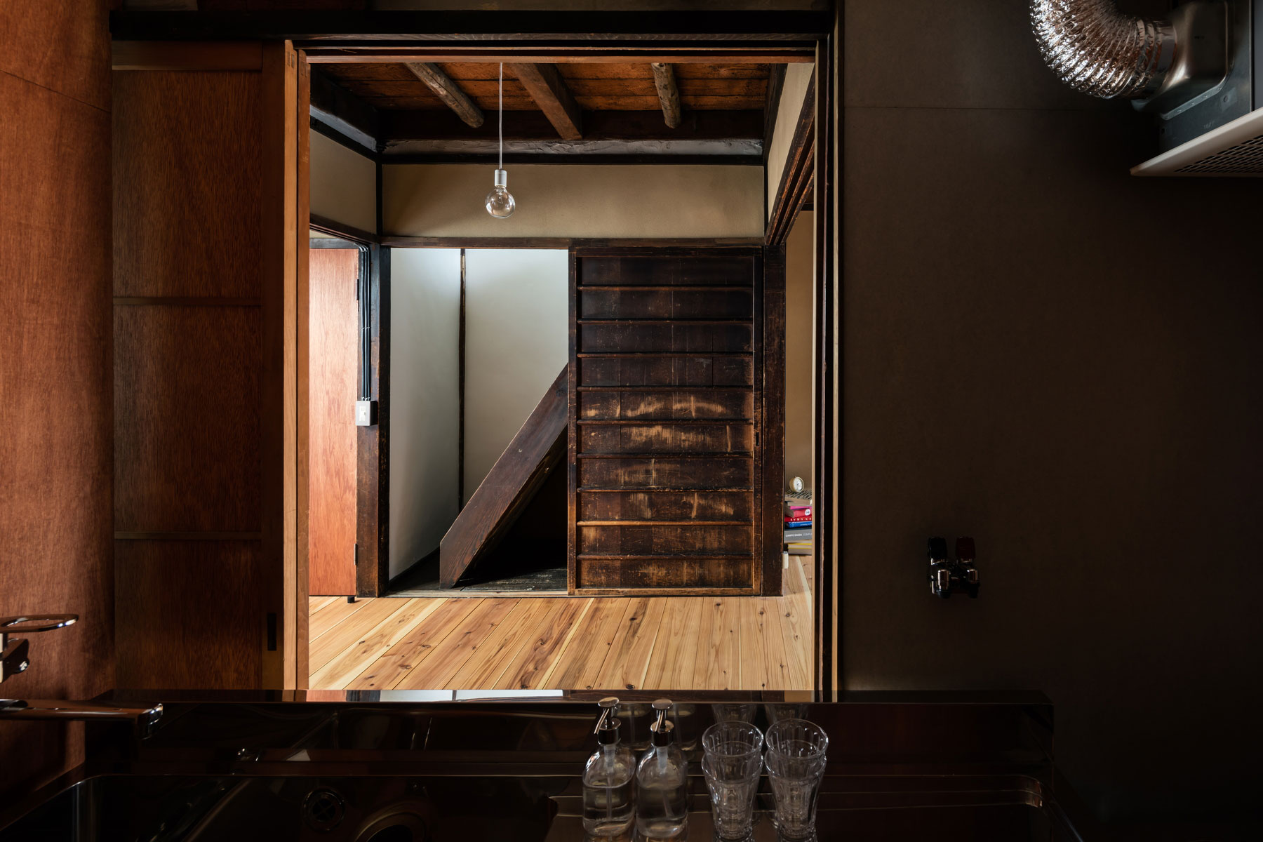 キッチンは居間に向かって配置し、引違戸を開ければ対面キッチンとして利用できる仕組み。ダイニング天井は2階荒板表し。