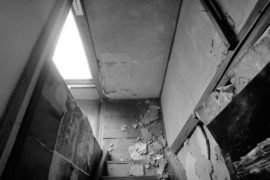 計画前の階段。長年の雨漏りで漆喰・土壁が剥落、白蟻被害も進む。