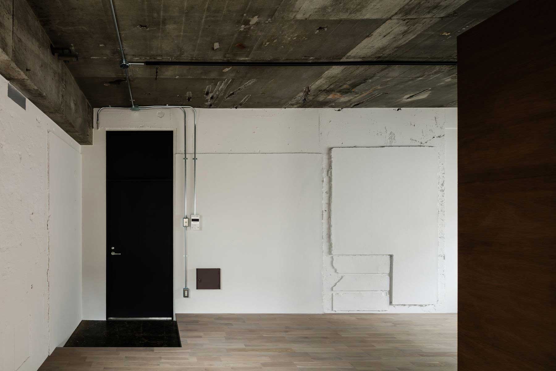 壁は既存躯体の凹凸ありのまま塗装。床はスモーク色に着色したオークフローリング。