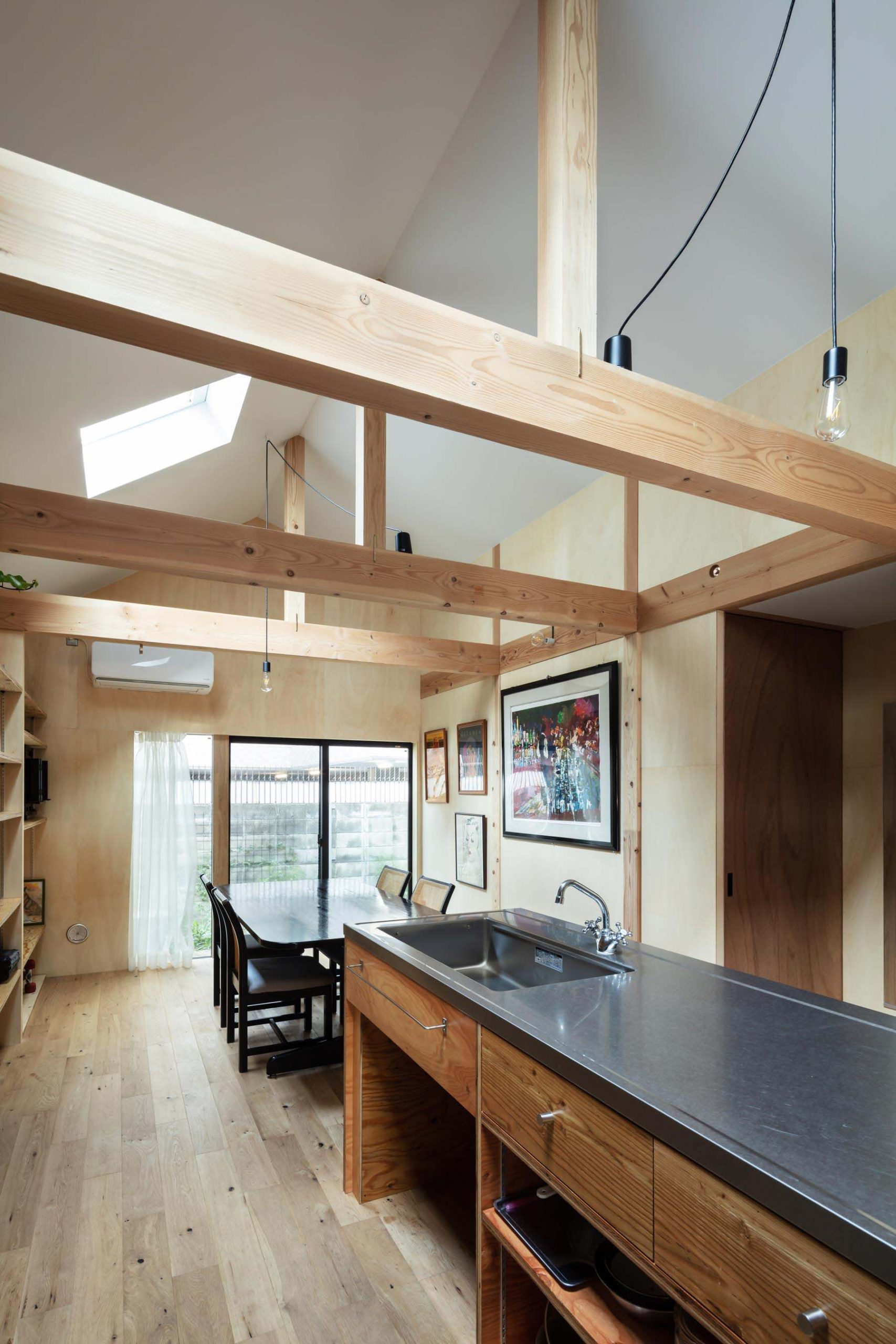 キッチンは構造用合板とステンレスバイブレーション仕上げの半既製品天板でシンプルに家具製作。