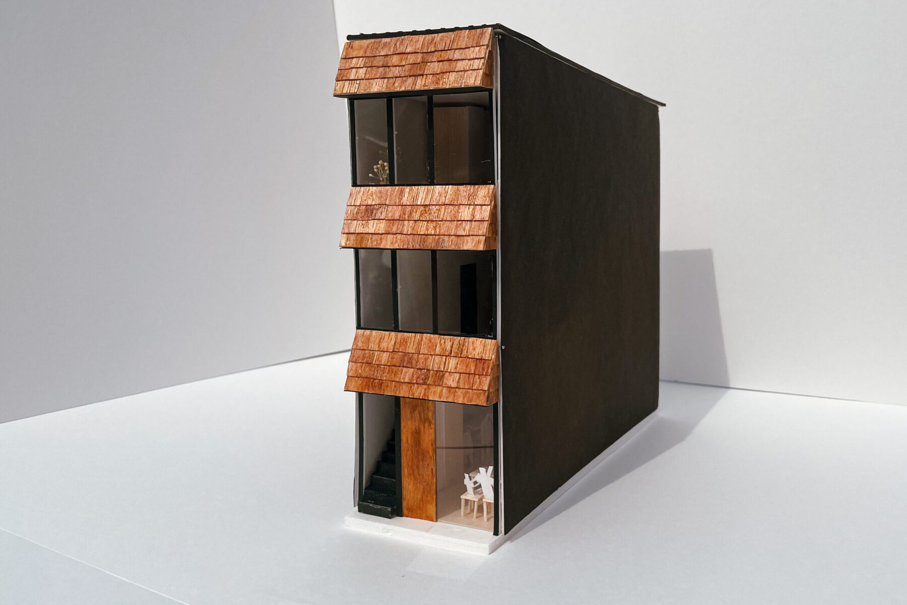 外観はオーニングテントのご要望を建築側に取り込み、各階にシングル葺の小庇を設けてウッディな雰囲気を残す。