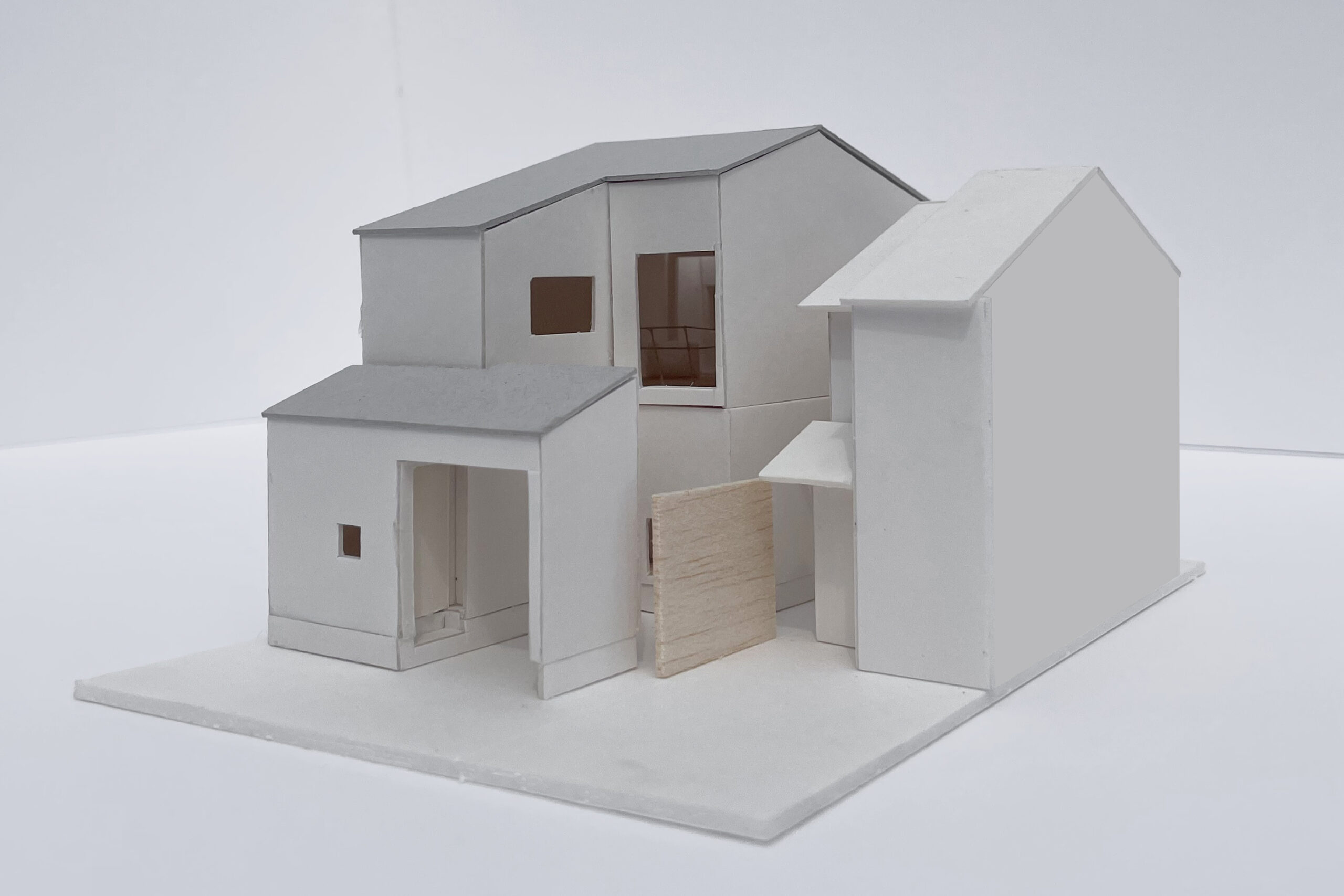 屋根は宇治市の条例に従い３寸勾配の切妻とし、さらに道路側は軒を低く抑えて南側からの光を取入れながら、街並みに対して優しい表情の佇まいとしました。前庭は玄関ポーチと一部を共有して省スペース化を図り、来客時のガレージとしても利用出来る間口を確保しています。