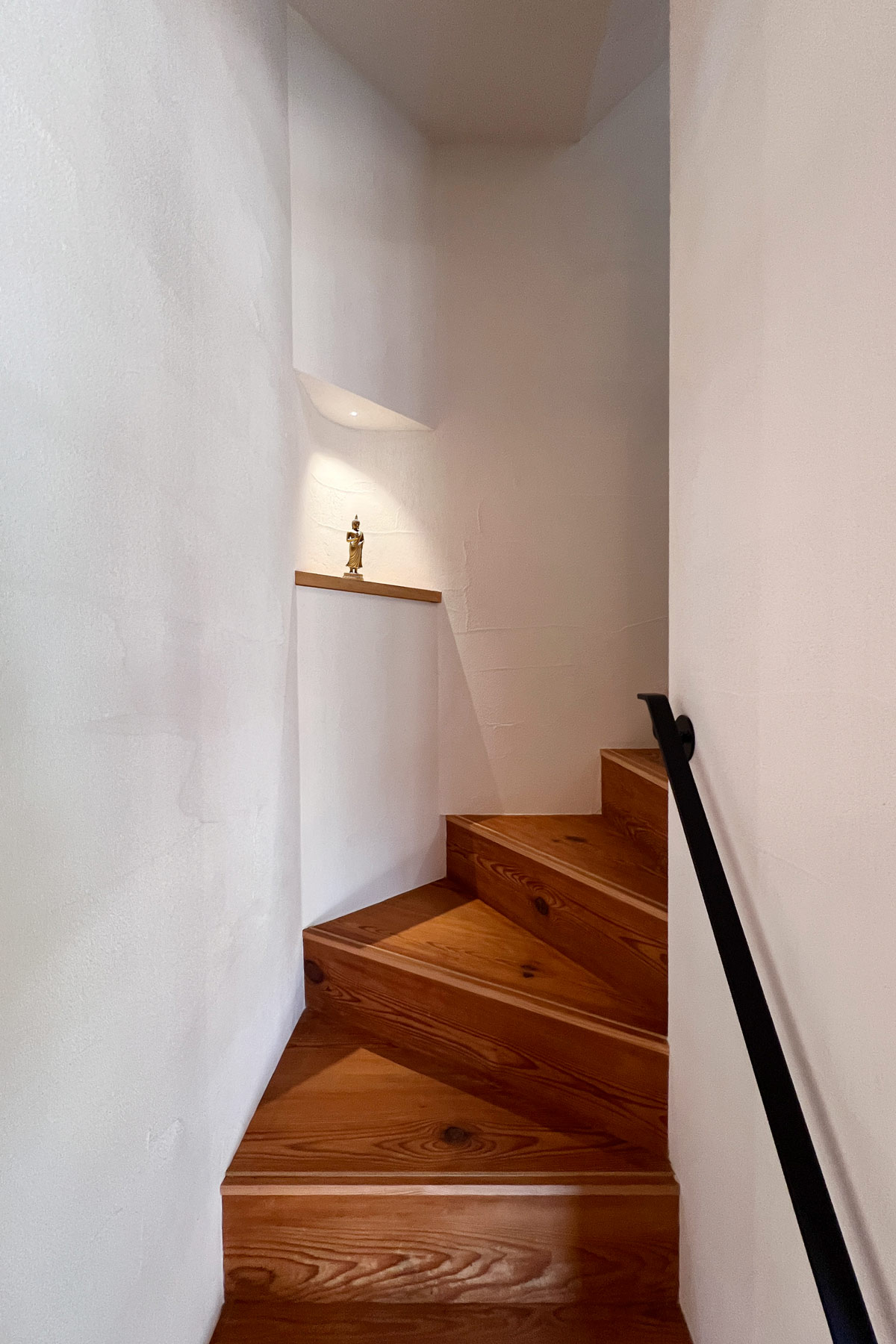 廻り階段の隅に出来る余白を利用したニッチ。リノベーションに際して不要になった分厚い床板を加工し蹴上・踏板に転用。