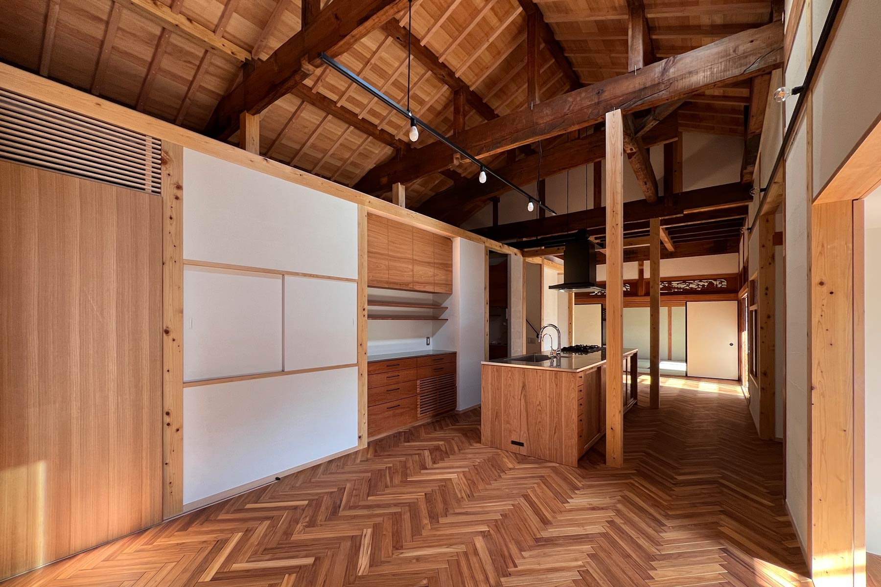 大きな気積の中に水廻り・収納を納めた箱を置く。天井はヘムロック、壁はドイツ漆喰、床はチークのヘリンボーン、建具はオーク、家具はチェリー。和洋の素材を適材適所に組み合わせ。