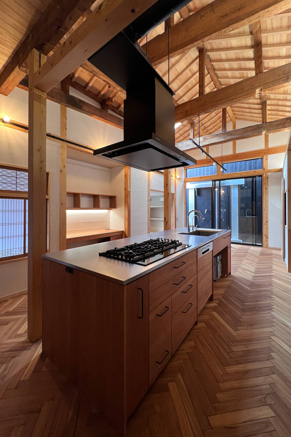 家具製作した大きなアイランドキッチン。ガスコンロは直列3口。レンジフードは梁から吊り下げ支持。